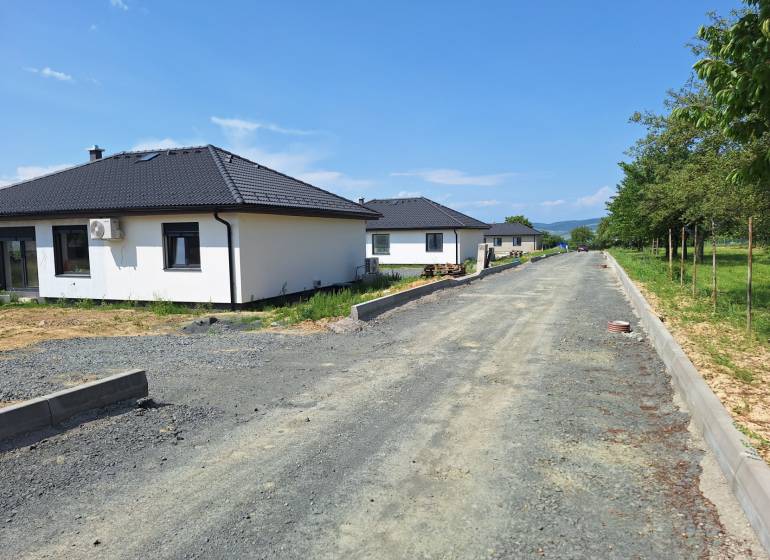 Einfamilienhäuser in der Straße Vyšná Šebastová in Prešov, umgeben von Grünflächen, neben einer unvollendeten Straße.