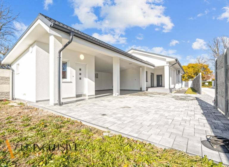 Ein Einfamilienhaus in Orechová Potôň mit weißer Fassade und gepflastertem Eingang.