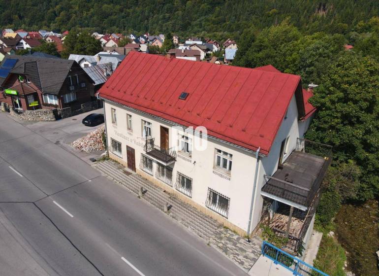 Das Gebäude in Belej mit dem roten Dach, die umliegenden Häuser und die Natur.