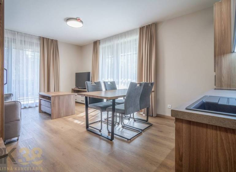 Wohnzimmer in einer 2-Zimmer-Wohnung mit Esstisch und Boden in Holzoptik.