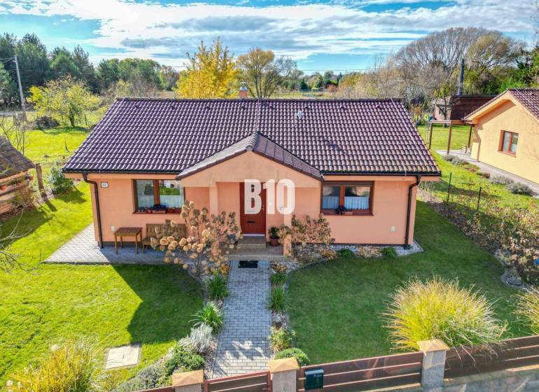 Ein Einfamilienhaus in Bílkove Humence mit gepflegtem Garten und terrakottafarbener Fassade.