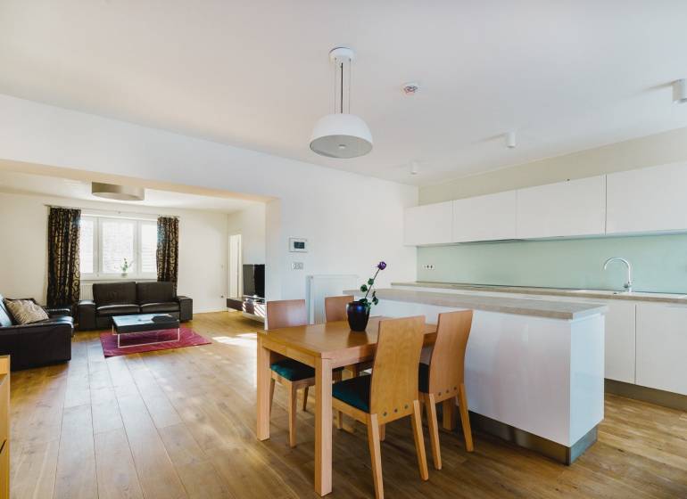 Küche und Wohnzimmer in einem Einfamilienhaus mit Holzboden und hellen Möbeln.