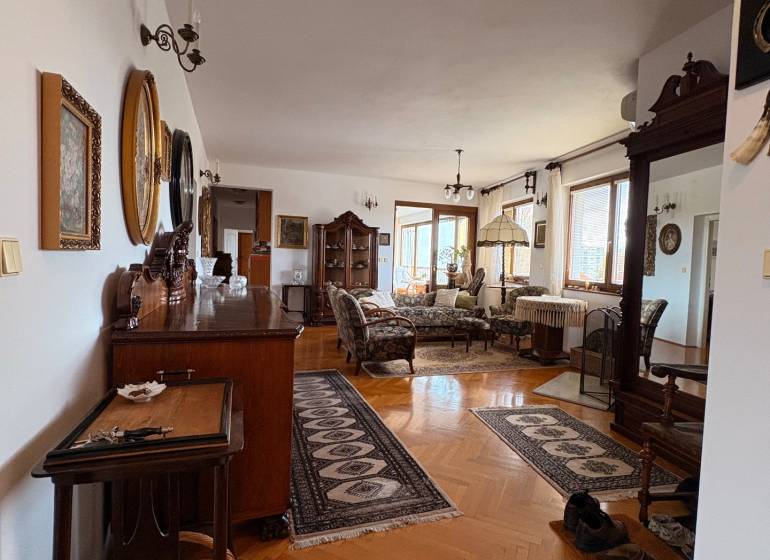 Eine Wohnung mit fünf oder mehr Zimmern, Holzboden, klassischem Möbel und Teppichen.