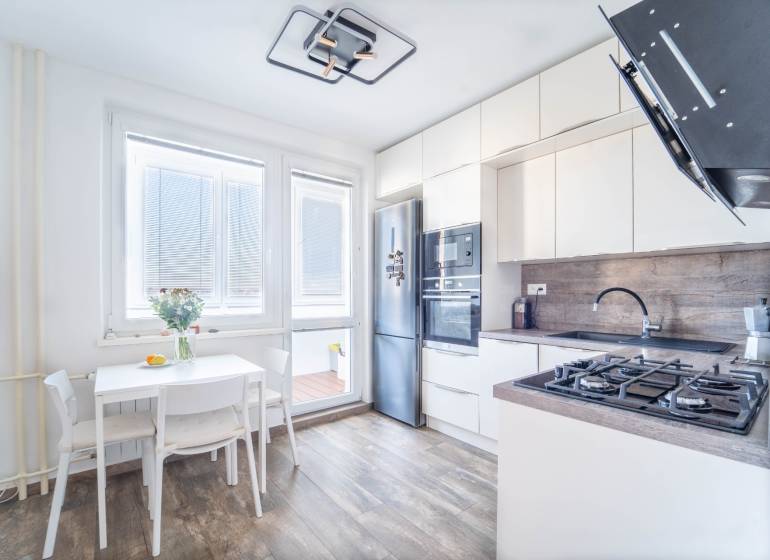 Küche in einer 3-Zimmer-Wohnung mit Holzboden und hellen Möbeln.