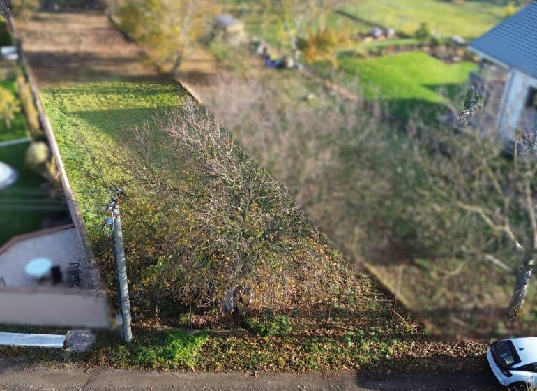 Baugrundstück in Dolná Krupá auf der M.H. Chvoteková, umgeben von Grünflächen und Bäumen.