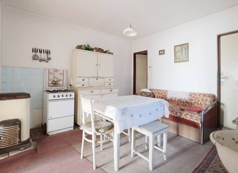 Esszimmer mit Gasherd, Tisch und Sofa in einem Einfamilienhaus, Boden mit Holzdekor.