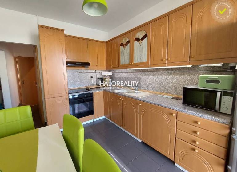 Küche in einer 3-Zimmer-Wohnung mit Holzküche und grünen Stühlen.