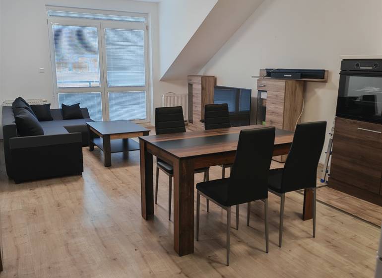 Wohnzimmer in einer 3-Zimmer-Wohnung mit Holzboden und Esstisch.