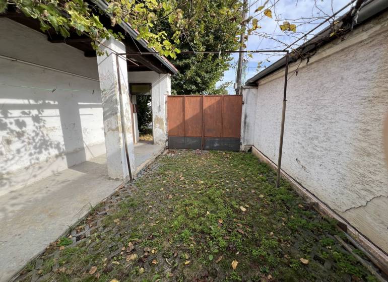 Der Hof des Einfamilienhauses in Jablonec mit Steinpflaster und Grünflächen.