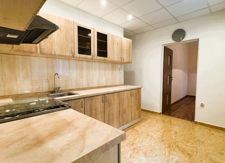 Küche in einer 3-Zimmer-Wohnung mit Küchenzeile und Boden in Holzoptik.