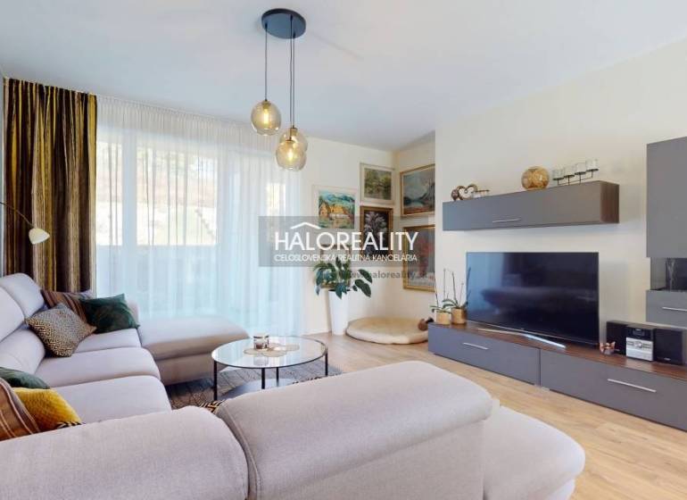 Wohnzimmer in einem Einfamilienhaus mit einem bequemen Sofa und einem Boden in Holzoptik.