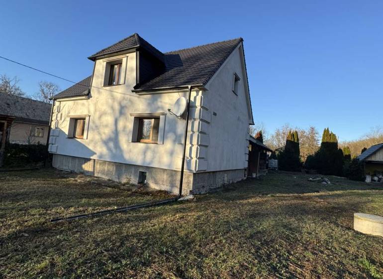 Ein Einfamilienhaus in Demandice mit zwei Etagen und einem begrünten Grundstück.