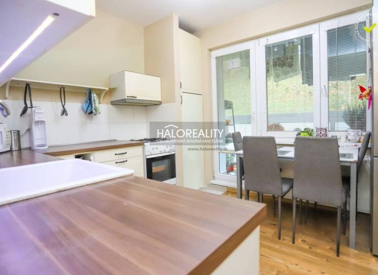 Küche in einer 2-Zimmer-Wohnung mit Holzboden, Esstisch und Geräten.