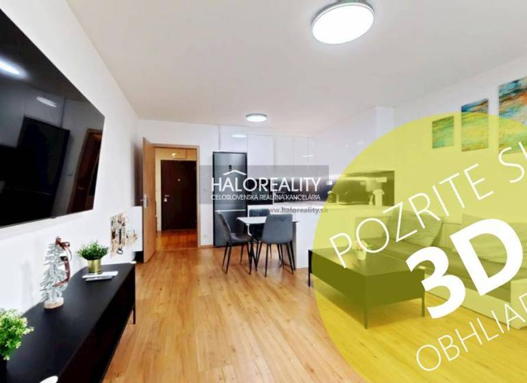 Wohnzimmer in einer Zweizimmerwohnung mit Holzboden, Essbereich und Fernseher an der Wand.