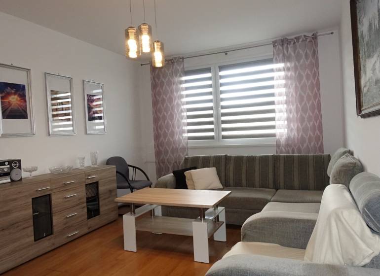 Helles Wohnzimmer mit Ecksofa, Couchtisch und Kommode in einer 3-Zimmer-Wohnung.