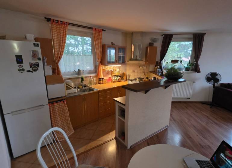 Küche in einer 3-Zimmer-Wohnung mit Holzboden und Esstisch.