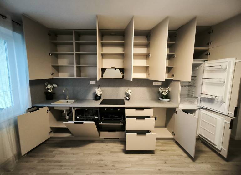 Küche in einer 4-Zimmer-Wohnung mit Holzboden, offenen Regalen und Geräten.