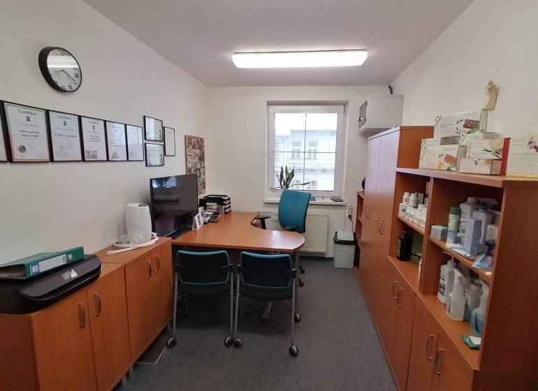 Büros mit Möbeln, Zertifikaten an der Wand und Regalen mit Produkten.