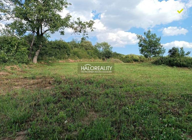 Ein Baugrundstück in Čerhov, umgeben von Grün und blauem Himmel.