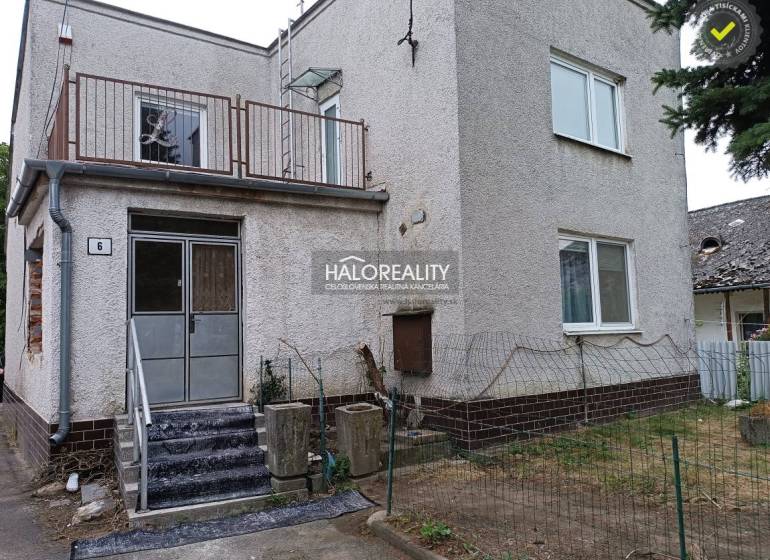 Ein Einfamilienhaus in Zemplín mit Treppe, Balkon und einem dünnen Zaun.