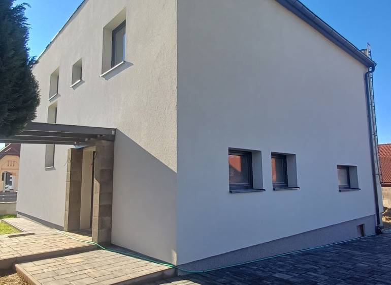 Ein Einfamilienhaus in der Košická-Straße in Rožňava mit einem eingezäunten Hof und einem gepflasterten Gehweg.