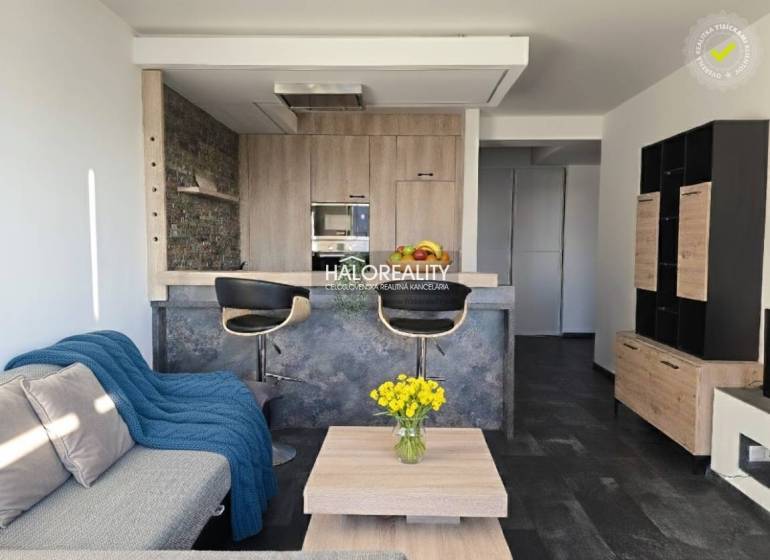 Wohnzimmer in einer 2-Zimmer-Wohnung mit offener Küche und Holzboden.