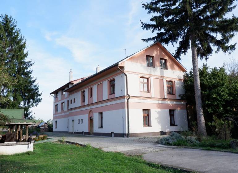 Das Gebäude in Poľný Kesov, umgeben von Grün, Hotels und Pensionen mit heimeliger Atmosphäre.