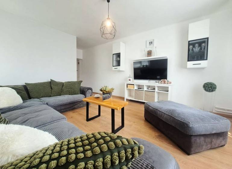 Wohnzimmer in einem Einfamilienhaus mit Holzboden und bequemer Sitzgarnitur.