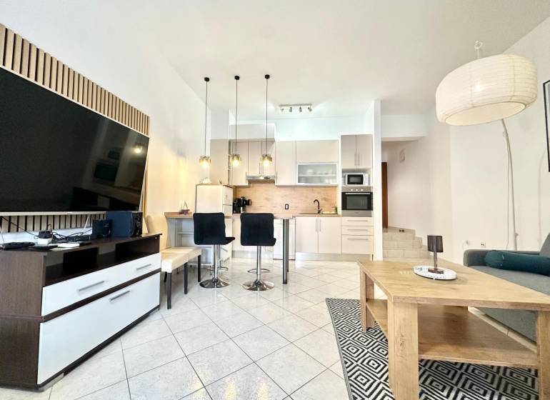 Ferienwohnung mit geräumigem Wohnzimmer, Küche und Fernseher.