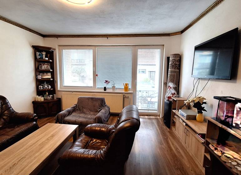 Wohnzimmer in einem Einfamilienhaus mit Ledermöbeln und Holzboden.