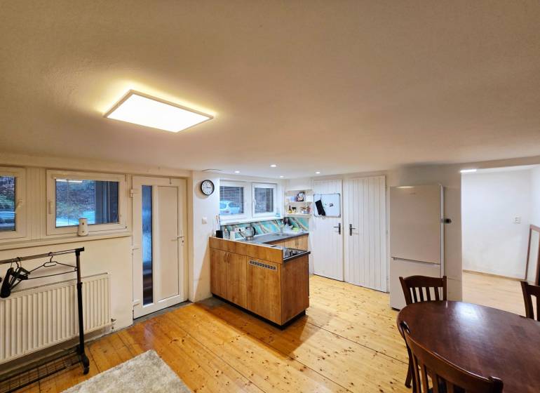 Küche in einer Einzimmerwohnung mit Holzboden und Tisch.