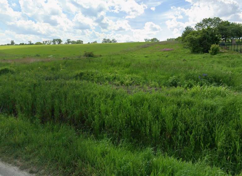 Baugrundstück in Lomnická, Vranov nad Topľou, mit Rasenfläche und hügeliger Landschaft.