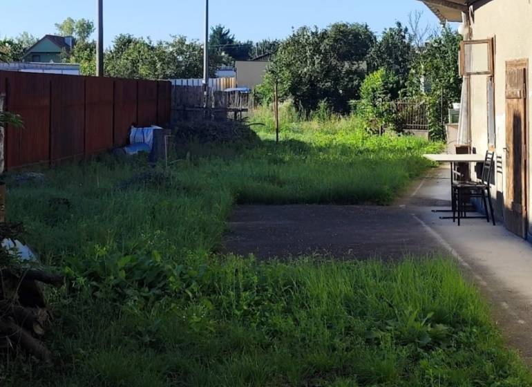 Der Hof in Reca ist zum Wohnen geeignet, die Grundstücke sind von einem Zaun und grünen Sträuchern umgeben.