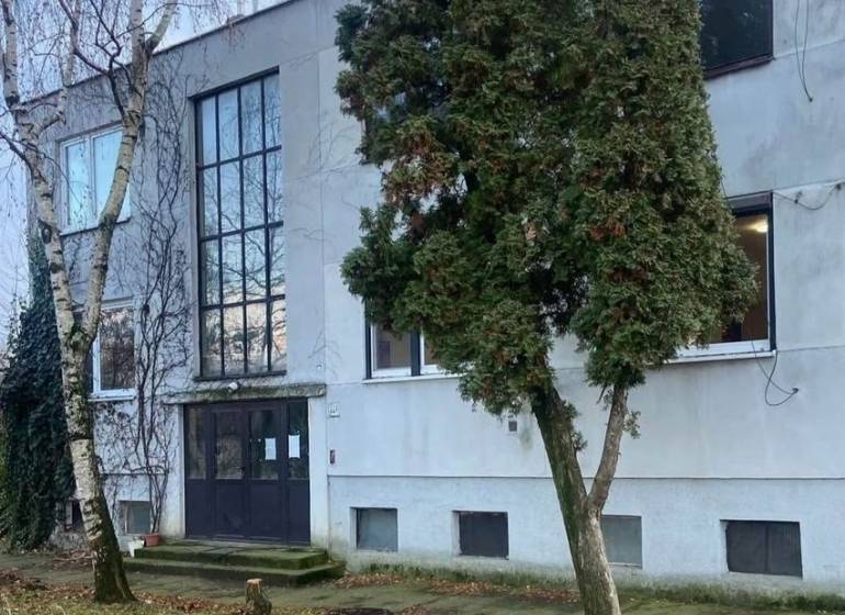 Das Äußere des Gebäudes in Selice, umgeben von Bäumen und einer grasbewachsenen Umgebung.