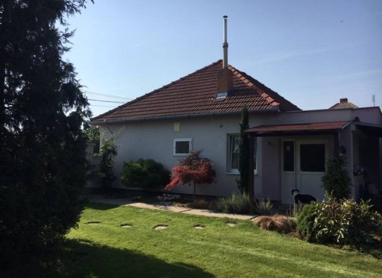 Ein Einfamilienhaus in Čierna Voda mit einem gepflegten Garten und einer Terrasse zum Entspannen.