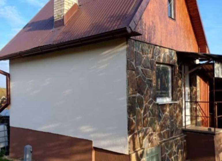 Hütte in Pozdišovce mit Steinfassade und braunem Blechdach.