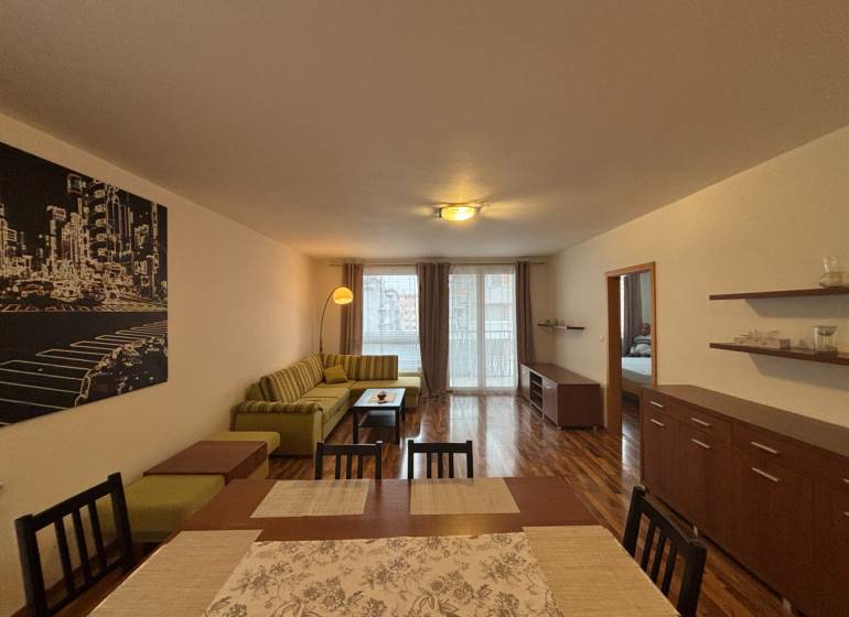 Wohnzimmer mit Holzboden, Sofa und Esstisch in einer Zweizimmerwohnung.