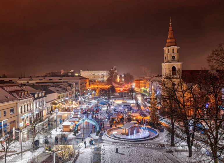 Winterliche Abendatmosphäre im Zentrum von Zvolen mit verschneiten Dächern und erleuchteten Straßen.