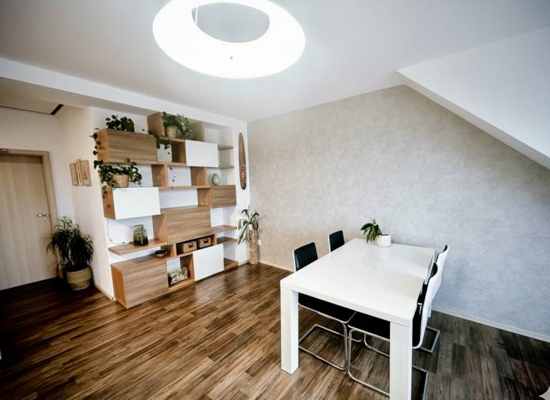 Esstisch, Stühle und Regale mit Dekorationselementen in einer 3-Zimmer-Wohnung mit Holzdekorboden.