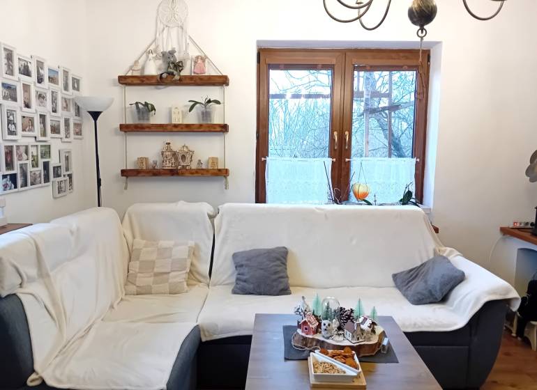 Wohnzimmer in einem Einfamilienhaus mit Sofa, Fotogalerie, Regalen und Dekorationen.