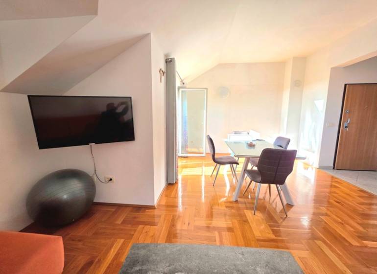 Innenraum einer Ferienwohnung mit Holzboden und Esstisch.