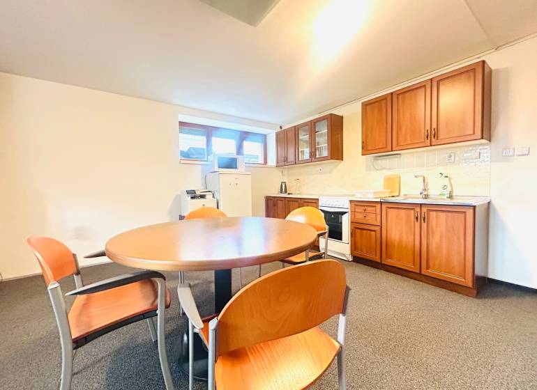 Eine Küche in einem Einfamilienhaus mit Esstisch, Stühlen und einer Küchenzeile mit Holzdekor.