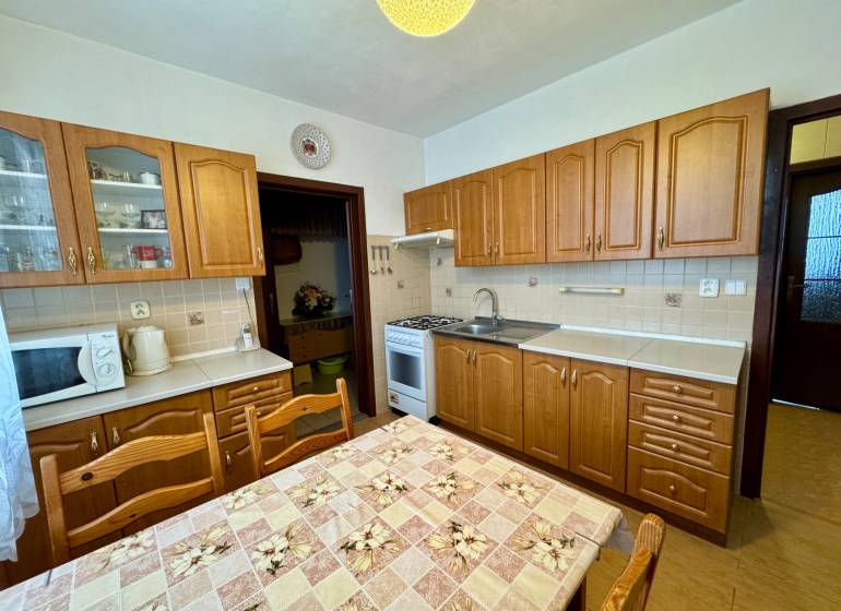 Küche mit Holzschränken und Esstisch, geeignet für eine 3-Zimmer-Wohnung.