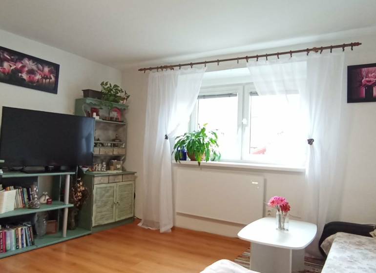 Wohnzimmer in einem Einfamilienhaus mit Holzboden-Dekor und Blumendekorationen.