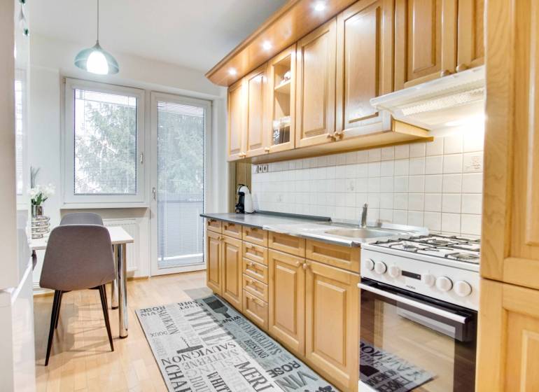 Küche in einer 4-Zimmer-Wohnung mit Holzboden und Esstisch.