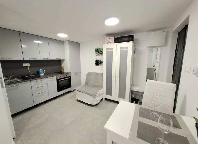 Eine Küche in einer Hütte, mit einem Esstisch und grauen Küchenschränken.