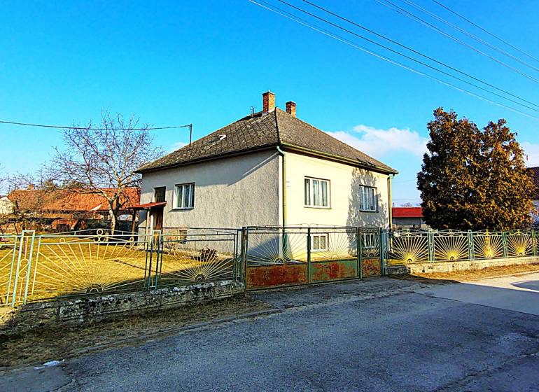 Ein Einfamilienhaus in der Sadova-Straße in Borský Mikuláš mit einem eingezäunten Garten und blauem Himmel.