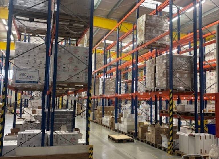 Regale in Lagern und Hallen voll mit gelagerter Ware auf Paletten.