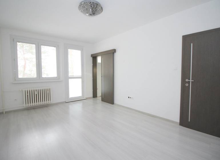 Helles Zimmer in einer 3-Zimmer-Wohnung mit Holzboden und großen Fenstern.