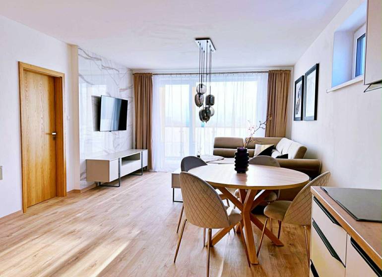 Wohnzimmer in einer 3-Zimmer-Wohnung mit hellen Möbeln und einem Boden in Holzoptik.